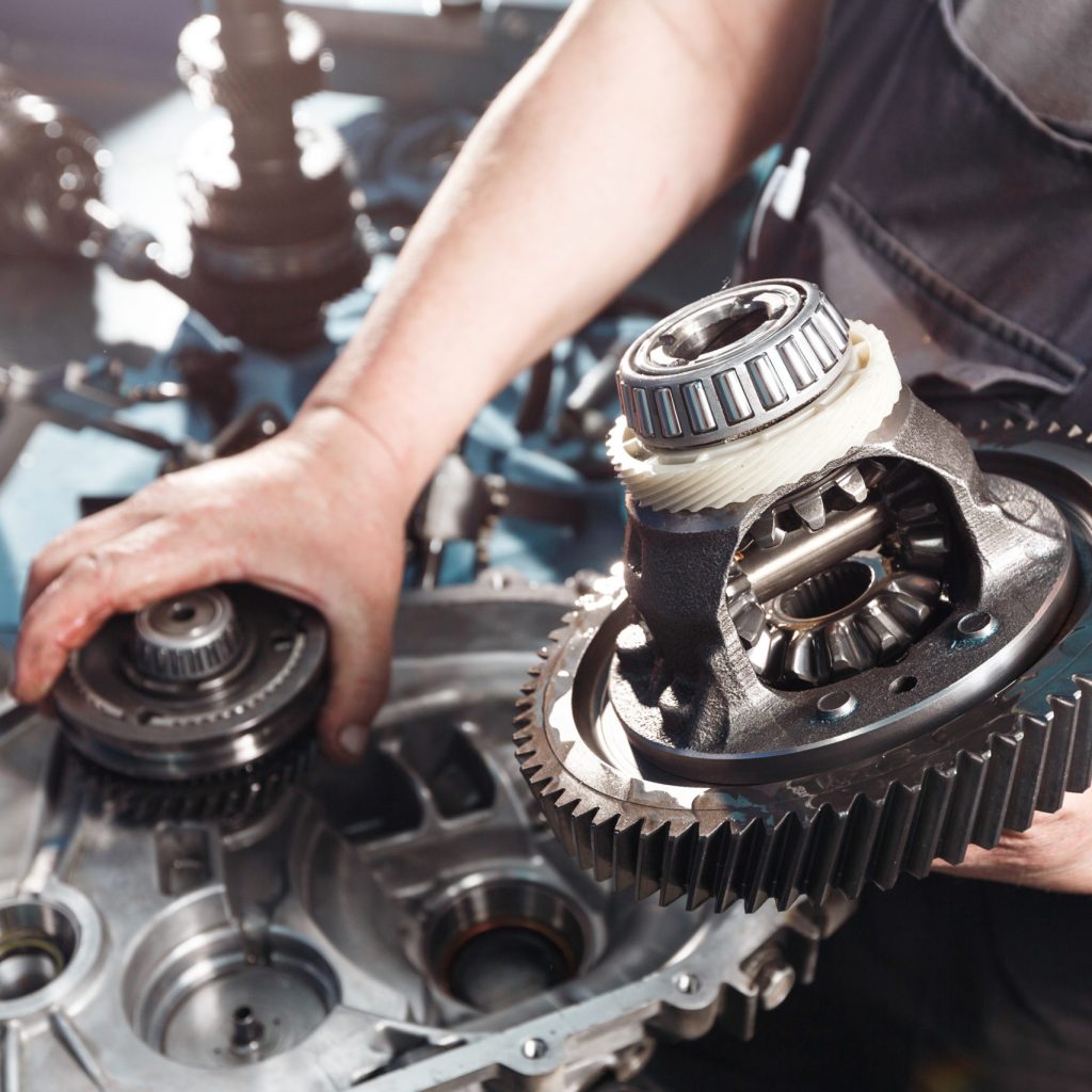 Cross-section of a car gearbox. mechanics work in the garage. hand car mechanic in working clothes.