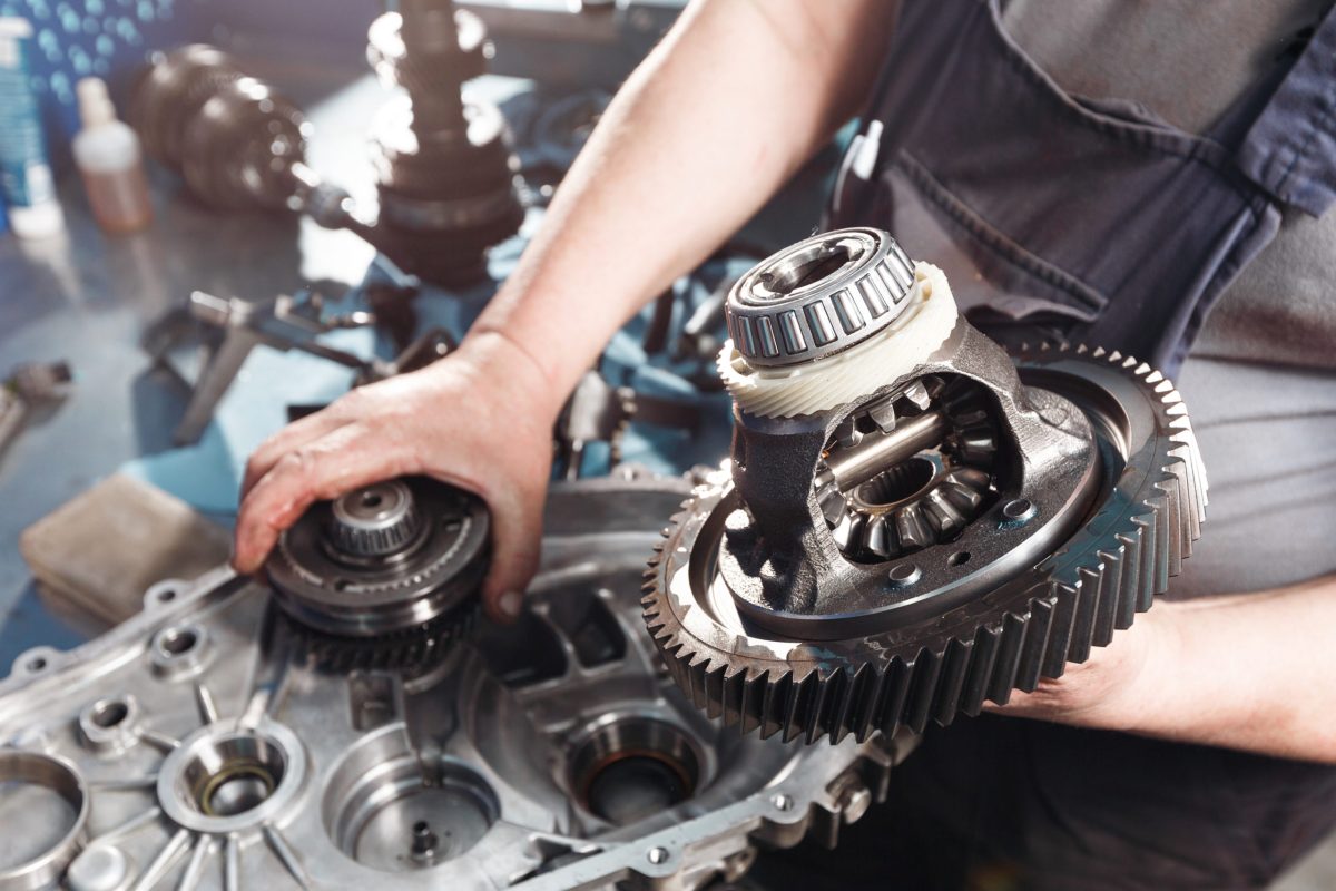 Cross-section of a car gearbox. mechanics work in the garage. hand car mechanic in working clothes.